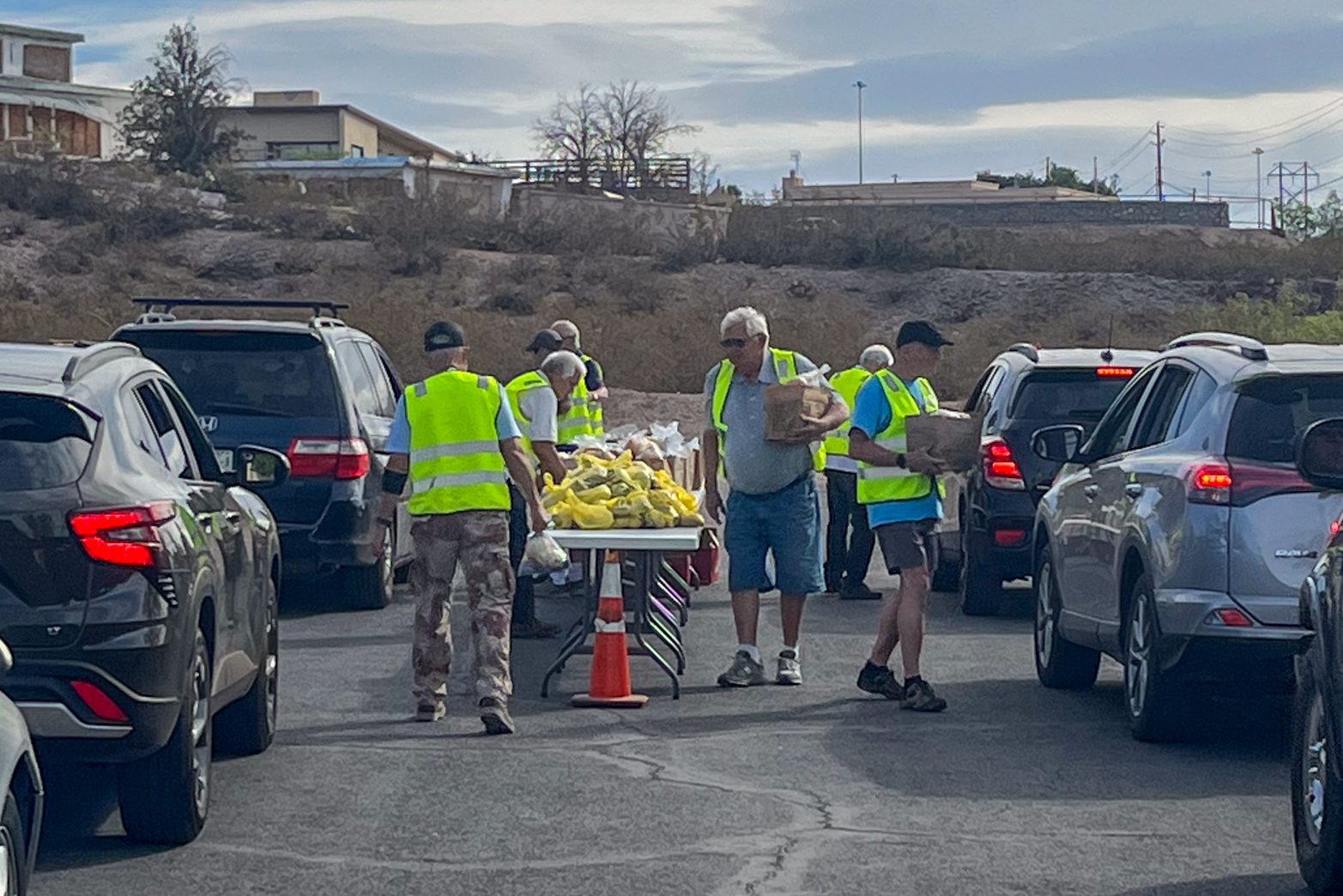 Members provide sacks of food to locals in need at the monthly food pantry distribution. Members